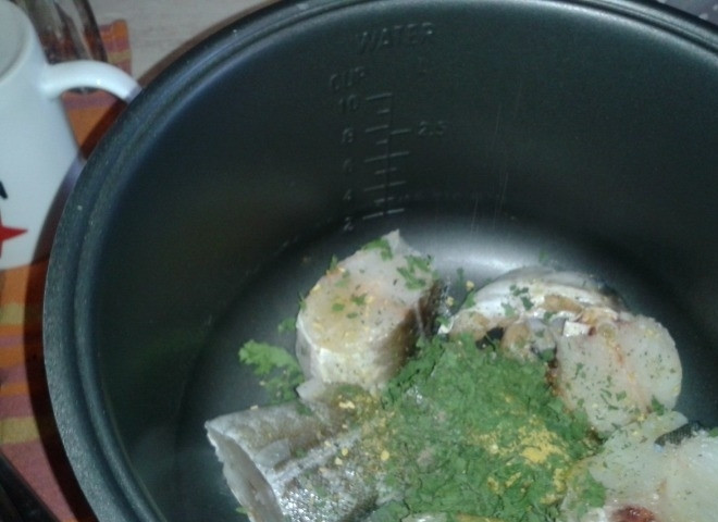 1. Этап. Треска, тушенная в мультиварке: Мелко порежьте петрушку, добавьте её к рыбе, посолите треску и поперчите. Подойдут также рыбные приправы.