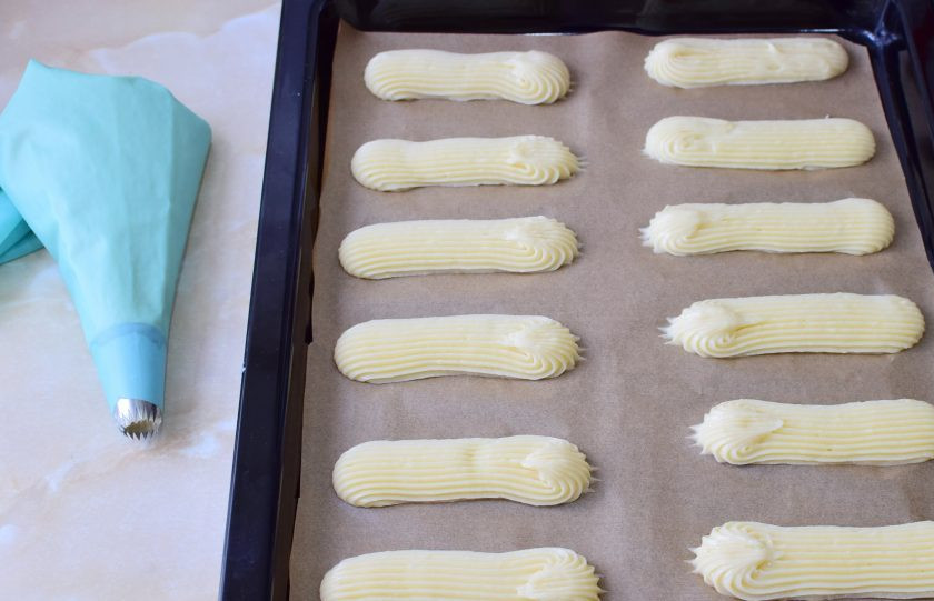 1. Этап. Французские эклеры: С помощью кондитерского мешка с насадкой отсадите эклеры на пергамент. Поставьте в духовку, предварительно разогретую до 180 градусов, примерно на 30 минут.