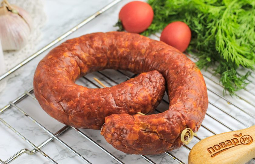 1. Этап. Домашняя варено-копченая колбаса: Затем скрутите колбаску и наколите ее шпажкой или свяжите кулинарным шпагатом, нитью, чтобы она не раскрутилась. Поместите в коптильню и прокоптите примерно 3-4 часа в зависимости от толщины. Если у вас нет коптильни, то можно попросить подкоптить колбасу и другие мясные продукты у фермеров. После коптильни проветрите колбасу минимум 2-3 часа.