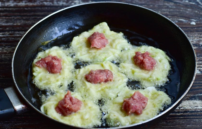 1. Этап. Колдуны из кабачков: В сковороде разогрейте растительное масло. Выложите лепешки из кабачковой массы. Затем в центр каждой выложите мясной фарш.