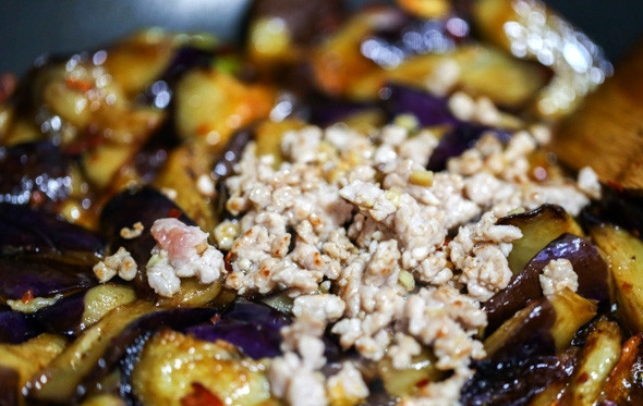 1. Этап. Тушеные баклажаны с мясом: 5. Переложите фарш к баклажанам. Добавьте чеснок, щепотку сахара, соевый соус, перец по вкусу. Аккуратно перемешайте и оставьте тушиться на медленном огне до готовности (около 15 минут).