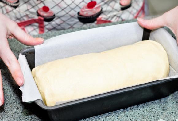 1. Этап. Хлеб с корицей: 7. Плотно свернуть рулетом по широкой стороне и выложить в форму, выстеленную пергаментом, швом вниз. Накрыть чистым сухим полотенцем и дать подняться в 2 раза, около 1-1 1/2 часа.