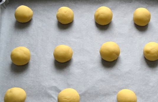 1. Этап. Сырцовые пряники: Отщипните кусочек теста, скатайте в шарик и выложите на противень, застеленный пергаментом.