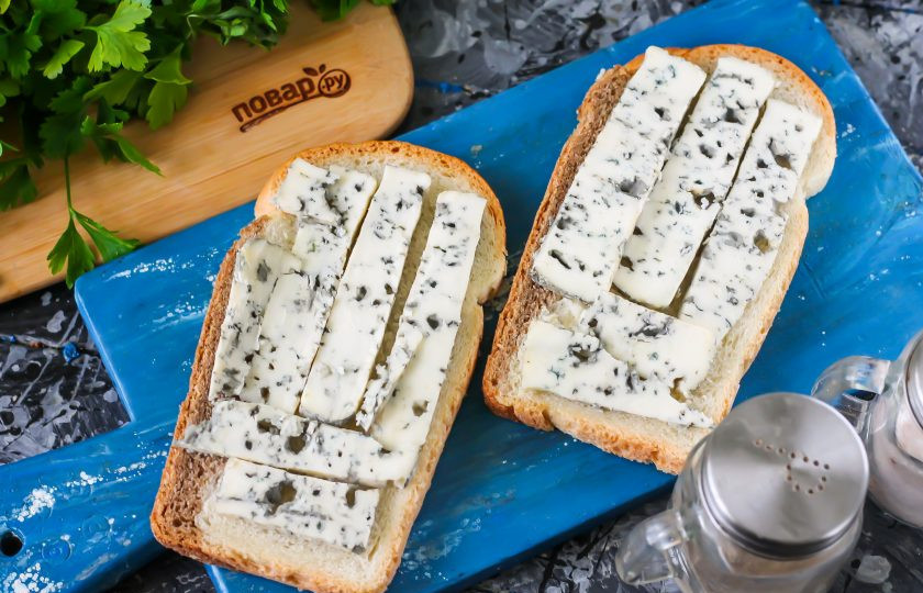 1. Этап. Мини-пицца Мумия: Хлебные ломтики любого сорта сбрызните оливковым маслом. По желанию можете использовать сливочное масло или обычное подсолнечное без запаха, но не майонез! Сыр с плесенью нарежьте небольшими полосками и выложите на ломтики хлеба.