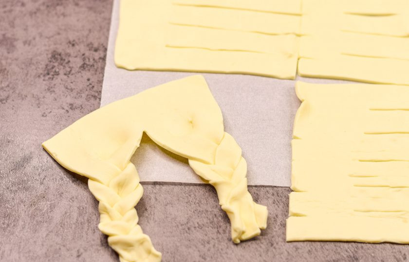 1. Этап. Плетеные Хот-доги из слоеного теста с плавленым сыром: Теперь сплетите две косички, как показано на фото.