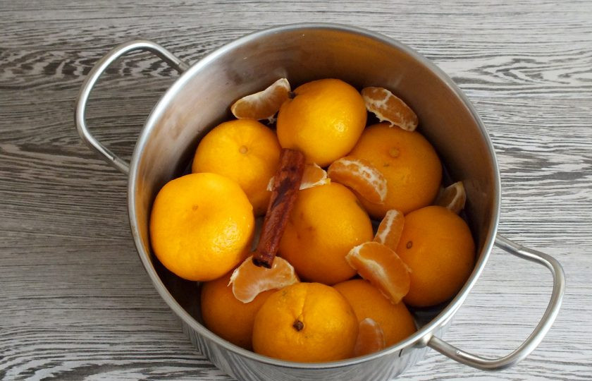 1. Этап. Варенье из целых мандаринов: Мандарины переложите в кастрюлю с толстым дном. Один плод очистите, разделите на дольки и выложите в кастрюлю. Залейте 300 мл. воды, положите палочку корицу. Закройте крышкой и оставьте на 5 часов при комнатной температуре.