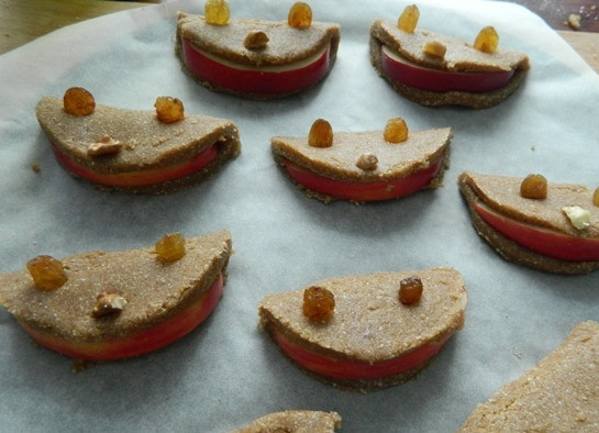 1. Этап. Печенье из гречнево-овсяной муки с яблоком: 6. Накрываем дольку второй половинкой кружочка и делаем глазки из изюма, а носик — из семечек или орехов. Перекладываем печенье на противень, застеленный пергаментом.