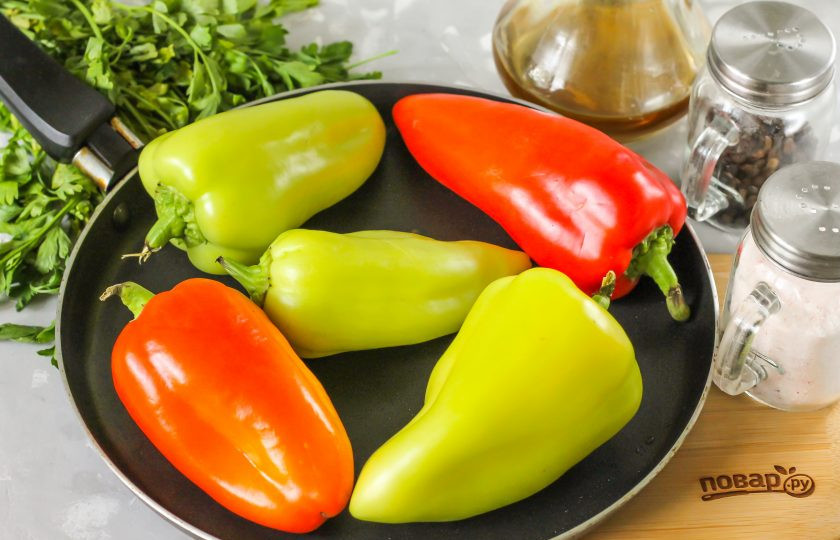 1. Этап. Жареный болгарский перец в маринаде: Перец тщательно промойте в воде и вытрите насухо. Вытирать обязательно, иначе масло начнет стрелять при выкладке в него овощей! Прогрейте сковороду с растительным маслом на плите и выложите в него перцы. Накройте крышкой и обжаривайте на среднем нагреве.