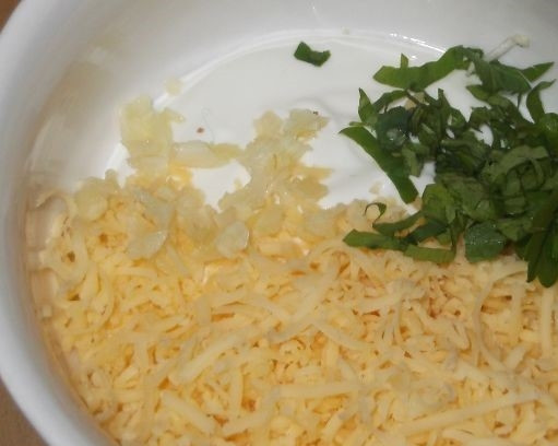 1. Этап. Кольца кальмаров в кляре: 5. Натрите твердый сыр, очистите чеснок и выдавите его через чесночницу. Измельчите зелень. Смешайте все ингредиенты соуса и добавьте сметану. Тщательно перемешайте.