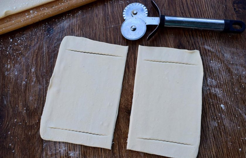 1. Этап. Лодочки из слоеного теста: 4. Тесто разрежьте на 8 равных квадратиков, раскатайте немного каждый, и сделайте два надреза вдоль, отступая по 1 см от края.