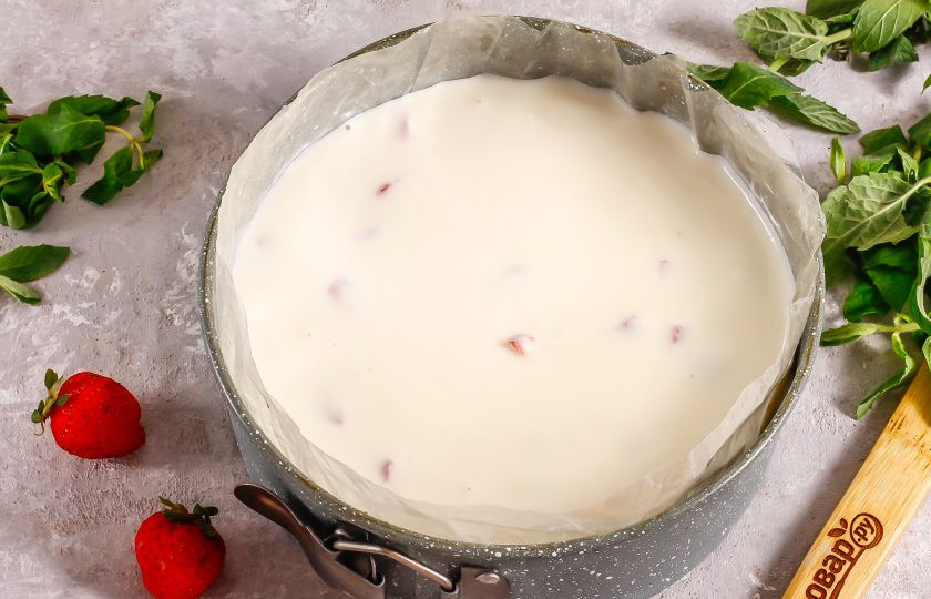 1. Этап. Клубничный чизкейк с творогом без выпечки: Извлеките форму из холодильника и выставьте кольцо из целлофана или выложите пищевую пленку на бортики. Залейте творожную массу и поместите форму снова в холодильник примерно на 1 час.