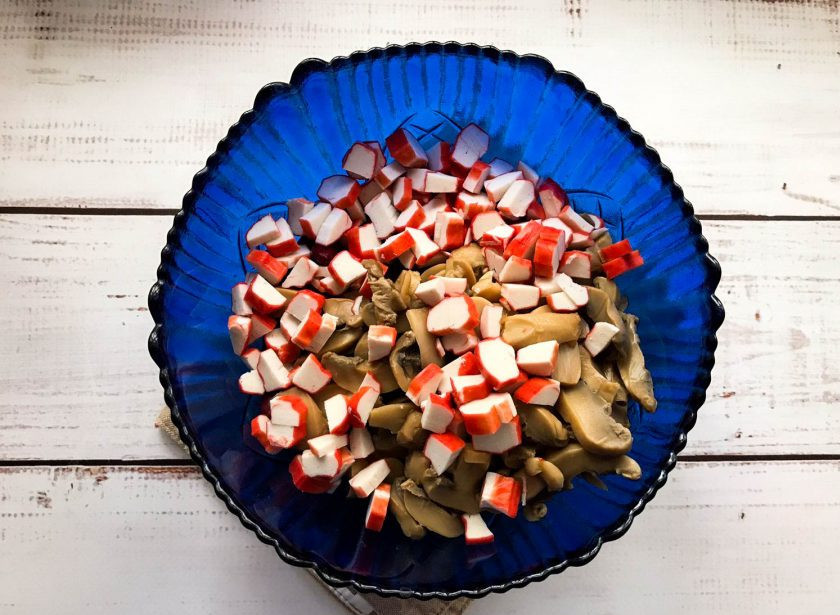 1. Этап. Салат с фасолью, грибами и крабовыми палочками: Крабовые палочки мелко нарежьте и выложите в тарелку.