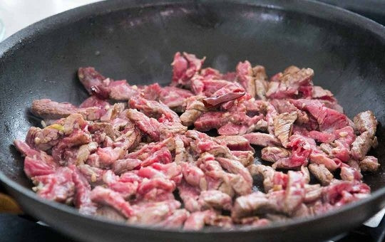 1. Этап. Говядина со сладким перцем: 5. Добавьте оставшееся масло, выложите мясо и жарьте до готовности, постоянно помешивая. В конце добавьте овощи, соевый соус по вкусу, выложите по желанию помидорчики и измельченную зелень. Снимите с огня и подавайте говядину со сладким перцем к столу. Приятного аппетита!