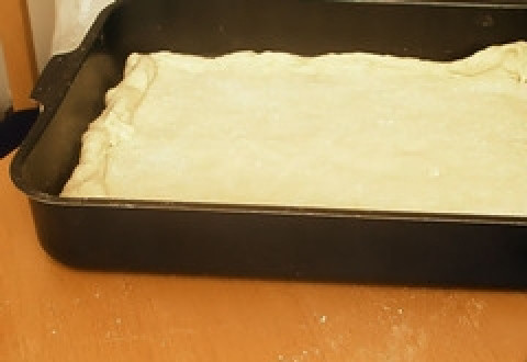 1. Этап. Пирог со щавелем: Тесто готово, беремся за формирование пирога. Небольшую часть теста оставляем для оформления верха. Раскатываем основную часть теста и выкладываем на противень так, чтобы получились бортики.