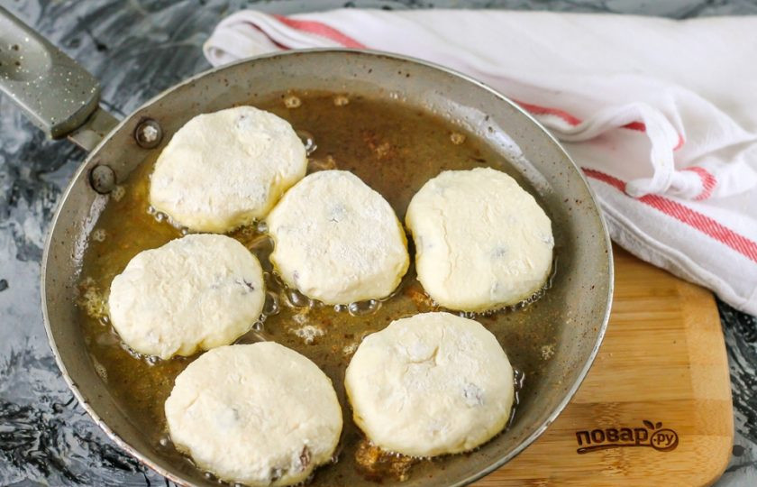 1. Этап. Сырники из кислого творога: Прогрейте на плите сковороду, выложите в нее сливочное масло и растопите, убавьте нагрев до среднего и поместите в масло творожные заготовки. Обжарьте около 2 минут с одной стороны до румяной корочки