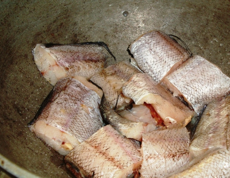 1. Этап. Рыба по-узбекски: Выложить в казан четверть лука, на него - рыбью голову, хвост и еще 1-2 куска рыбы. Присыпать 1/3 частью укропа, частью кориандра, добавить перец и лавровый лист. Затем вновь слой лука, несколько кусков рыбы, зелень, приправы. И так далее. Последний слой лука нужно слегка посолить. Плотно закрыть казан крышкой (при необходимости обернуть полотенцем) и томить на самом маленьком огне 1,5 часа.