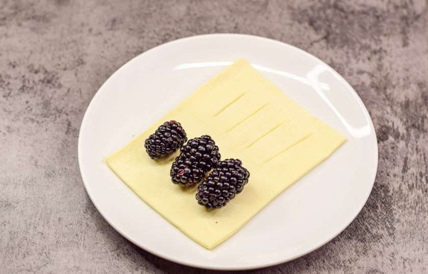 1. Этап. Слойки с ежевикой: На половину теста, которую не разрезали, выложите 3-4 ягоды ежевики.