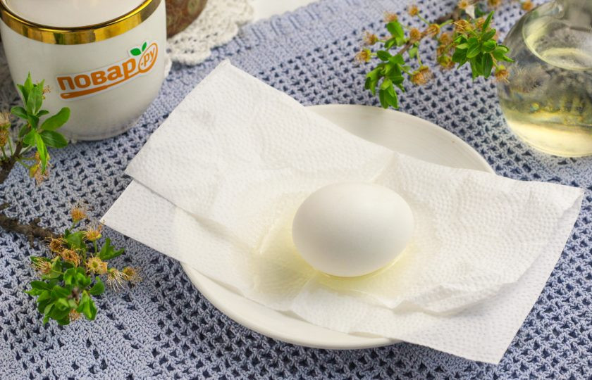 1. Этап. Яйца с поталью: Выложите на блюдце или тарелку бумажную салфетку и влейте на нее растительное масло без аромата. Выложите отварное куриное яйцо и смажьте его маслом со всех сторон.