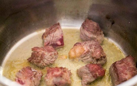 1. Этап. Овощи, тушенные с мясом в говяжьем бульоне: В сотейнике раскалите масло и выложите говядину. Жарьте на большом огне до золотистой корочки.