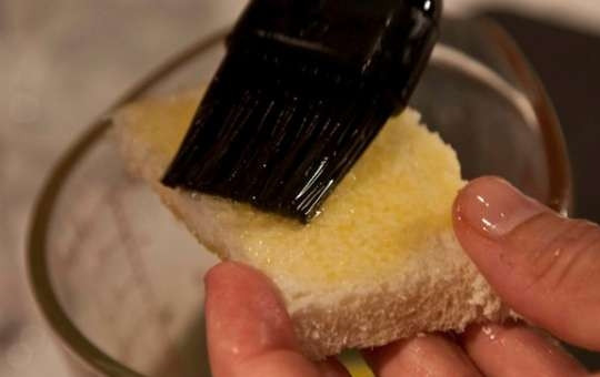 1. Этап. Шарлотка с грушами: 3. Отрежьте корки хлеба, оставьте только мякиш. Растопите сливочное масло, каждый кусочек хлеба смажьте им.