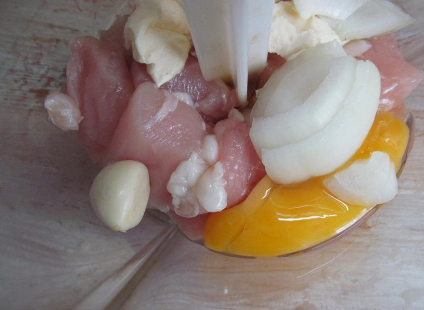 1. Этап. Картофельная запеканка с индейкой: Крупно нарезать филе индейки, половину лука, очистить чеснок и выложить в блендер, вбить яйцо и добавить сметану. Перебить все ингредиенты до образования однородной массы.