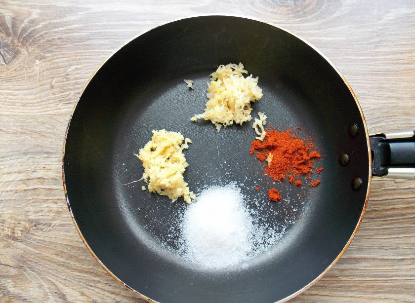 1. Этап. Сычуаньский соус: Очистите имбирь и чеснок от кожуры, мелко натрите. Положите имбирь и чеснок в сковороду. Добавьте сахар и паприку.