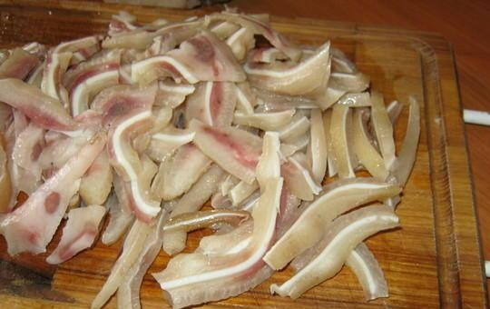 1. Этап. Свиные уши по-корейски: Отделите тонкую часть с хрящиком. Нарежьте её тонкой соломкой.