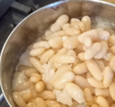 1. Этап. Запеканка с брокколи, фасолью, грецкими орехами: Добавить муку. Размешать. Вливать молоко небольшими порциями, постоянно помешивая, а затем довести соус до кипения и, уменьшив огонь, тушить его две минуты до загустения. Выключить огонь. Добавить в соус сыр чеддер, мускатный орех и фасоль. Тщательно перемешать.