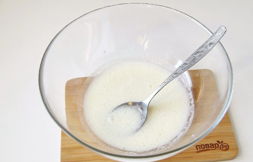 1. Этап. Пышные оладьи на кефире с манкой: Налейте кефир в глубокую миску. Добавьте сахар, соль, соду и перемешайте до появления пузырьков.