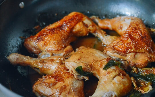 1. Этап. Курица в устричном соусе: Тонко нарежьте чеснок. У лука-шалота отрежьте белую часть и разрежьте её напополам. Добавьте лук и чеснок в сковороду к курице. Обжарьте все вместе на протяжении минуты. Следите, чтобы курица не пригорала к сковороде (только не порвите кожицу), достаньте её. Теперь влейте вино. Подержите его на огне ещё пару минут. Влейте куриный бульон, соевый и устричный соусы, добавьте перец и кунжутное масло. Перемешайте до полного смешивания ингредиентов. Доведите до кипения, после чего уменьшите огонь и томите все минут 15 под крышкой. Щипцами или палочками аккуратно выложите обратно в сковороду куриные кусочки. Готовьте ещё 15 минут. Соуса должно быть довольно много, но если вам кажется, что курица подсыхает, влейте еще немного бульона. Снимите крышку и добавьте к курице нарезанный довольно крупной лук-шалот (зеленую часть). Готовьте без крышки, чтобы жидкость испарялась (должна покрываться ложка).