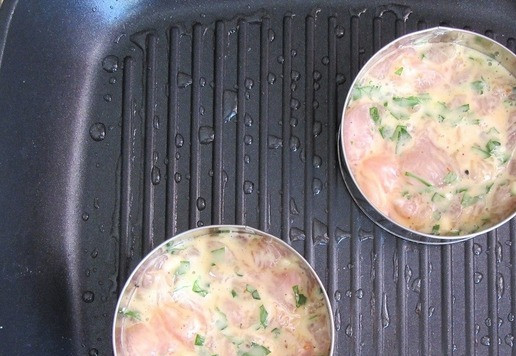 1. Этап. Чикенбургер с сыром и баклажанами: Подготовленную котлетную массу разделите на 5 частей. Каждую часть выкладывайте на разогретую сковороду-гриль в кулинарное кольцо, чтобы котлетки были ровными. Обжарьте с одной стороны.