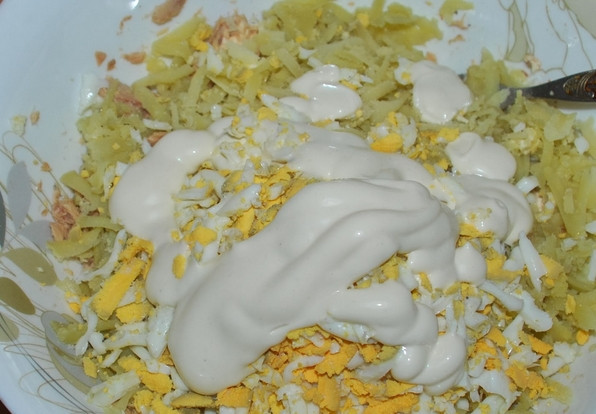 1. Этап. Cалат из рыбной консервы: Пропускаем через пресс чеснок и добавляем в салат. Солим по вкусу и заправляем майонезом. Перемешиваем.