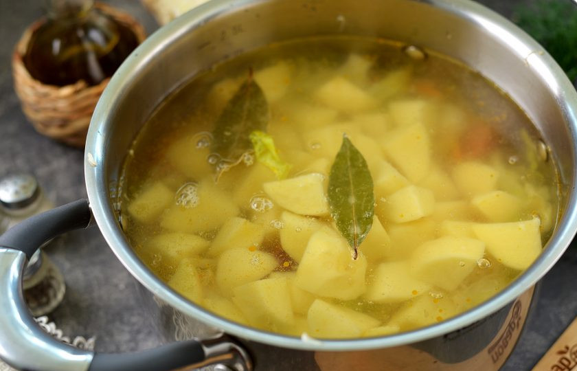 1. Этап. Капустняк по-польски со свежей и квашеной капустой: Картофель нарежьте крупным кубиком, добавьте в кастрюлю, влейте воду, выложите лавровый лист. После закипания воды варите суп около 25-30 минут, до полного приготовления картофеля.