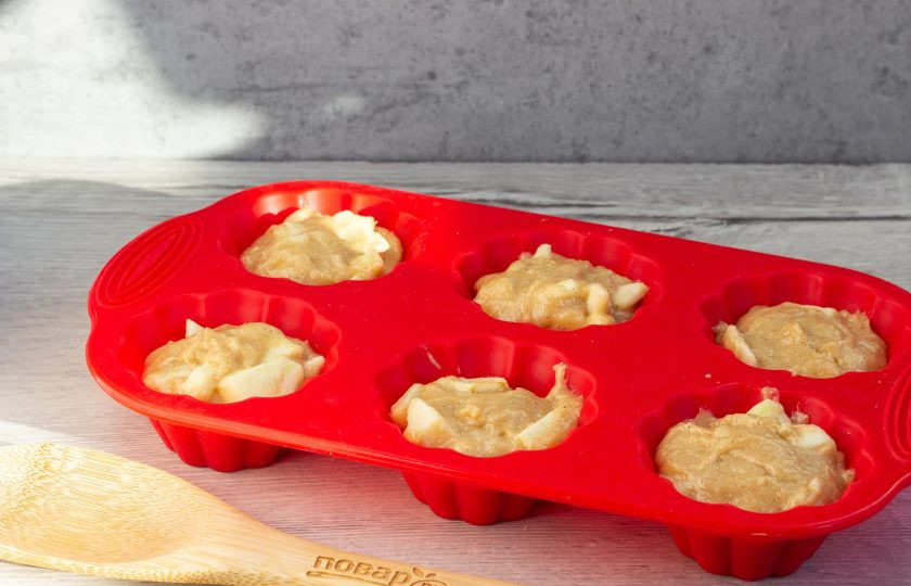 1. Этап. Пряные кексы: Добавьте яблоки в тесто, перемешайте. Разложите тесто в порционные формы. Силиконовые я ничем не смазываю, металлические можно смазать растительным маслом.