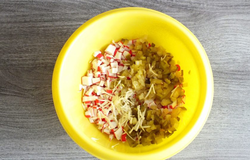 1. Этап. Крабовый салат в тарталетках: Огурец нарежьте мелким кубиком, чеснок натрите на терке или измельчите в прессе. Добавьте к крабовым палочкам.