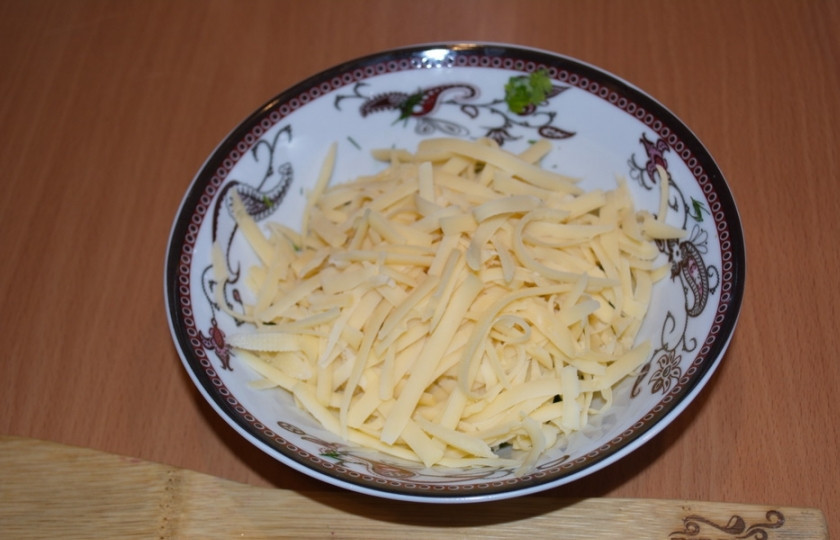 1. Этап. Пирог с сыром из дрожжевого теста: Натрите на терке твердый сыр. Выдавите через пресс чеснок. Перемешайте. Добавьте немного соли и специй. Для сочности пирога рекомендую натереть на терке 50-70 граммов сливочного масла и добавить его в начинку. Тогда сырная начинка будет вкуснее.