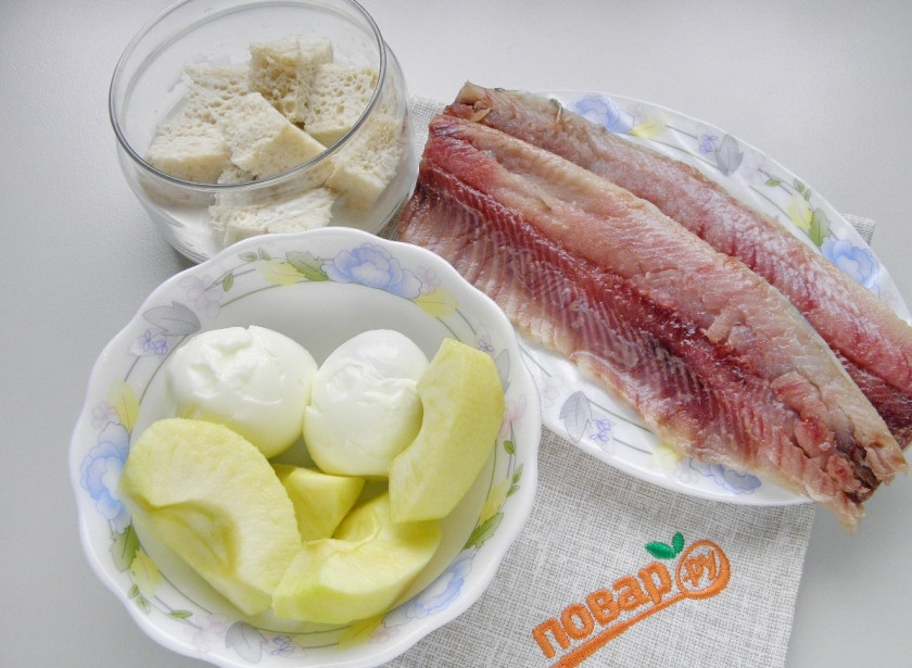 1. Этап. Форшмак из селедки классический: Разделайте селедку на филе, удалите внутренности, голову, кости и кожу. С хлеба срежьте корочки и замочите его в молоке. Яблоко вымойте, снимите кожуру и удалите сердцевину. Перекрутите все продукты два раза через мясорубку. Исключение: один желток, он понадобится для украшения блюда.