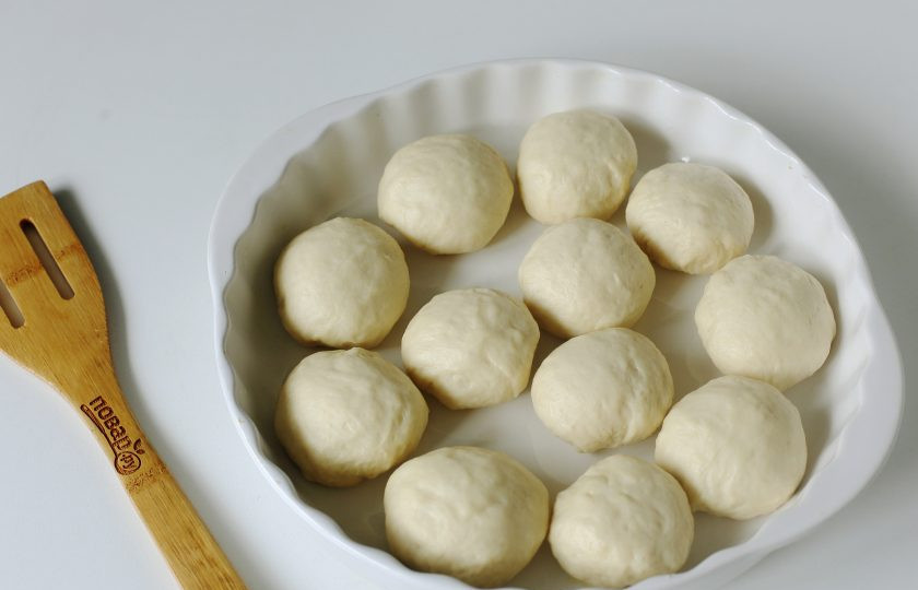 1. Этап. Чесночные пампушки на кефире: Разделите тесто на 10-12 частей, сформируйте шарики и переложите их на смазанный маслом противень на некотором расстоянии друг от друга. Накройте и оставьте еще на 40 минут.