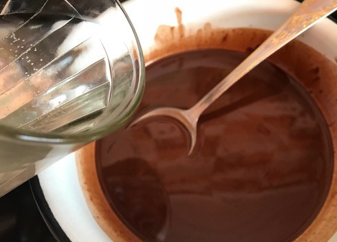 1. Этап. Шоколадные кексы с бананом и черной смородиной: 3. В растопленный и слегка остывший шоколад с маслом добавьте воду комнатной температуры.