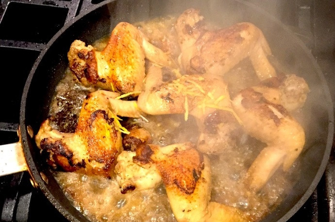 1. Этап. Куриные крылышки с Coca-Cola: 9. Влейте в сковороду к куриным крыльям стакан напитка, добавьте цедру и сок лимона. Уменьшите температуру до минимума и накройте сковороду крышкой, готовьте около 10-15 минут.