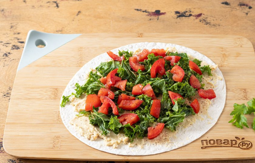 1. Этап. Лаваш с хумусом: Выложите сверху кейл и помидоры, посолите и поперчите. Заверните лаваш в плотный рулет.