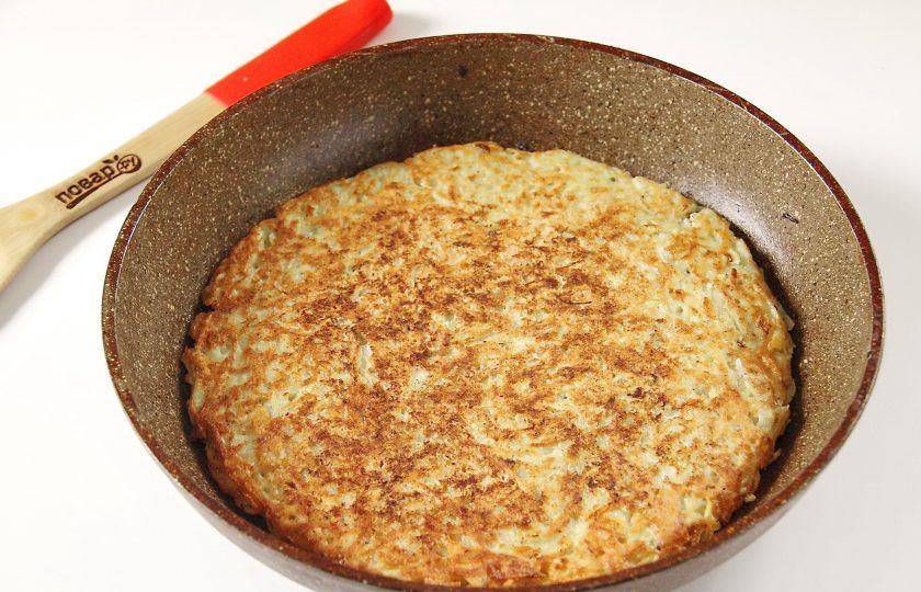 1. Этап. Картофельная запеканка на сковороде: Выложите картофельную массу на сковороду, смазанную маслом и обжарьте с одной стороны до появления румяной корочки. Затем аккуратно переверните поджаристой стороной верх и убавьте огонь.