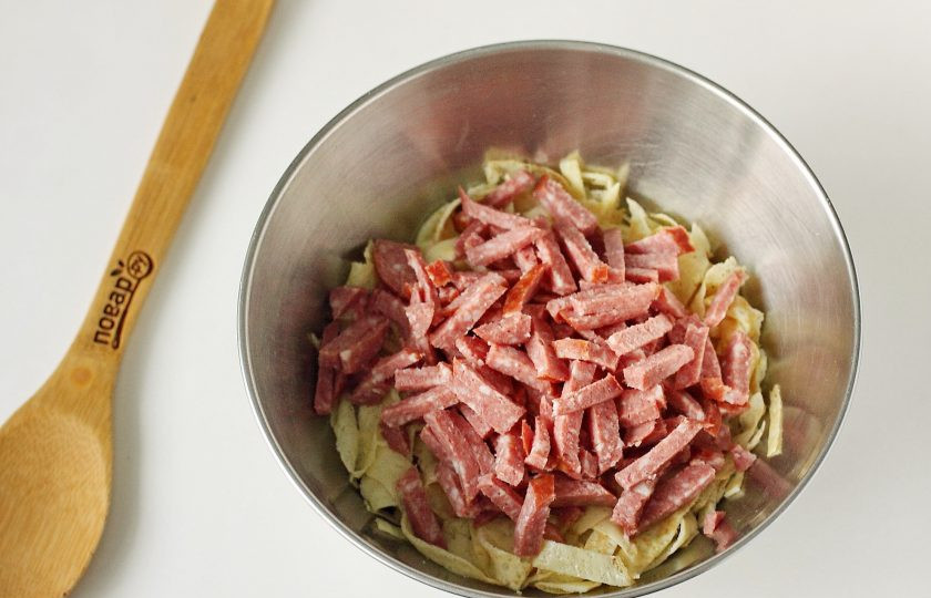 1. Этап. Блинный салат: Добавьте нарезанную небольшой соломкой колбасу.