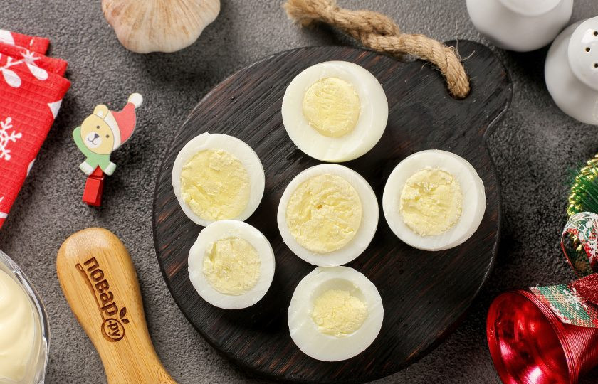 1. Этап. Фаршированные яйца Новогодние драконы: Каждое яйцо очистите от скорлупы и разрежьте поперёк на две неравные части (одна часть должна быть чуть больше другой). Вытащите из двух половинок желток. Большие половинки отложите, мы их будем фаршировать.