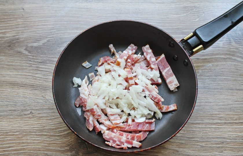 1. Этап. Гратен с беконом: Лук почистите и мелко порежьте, добавьте его к бекону.