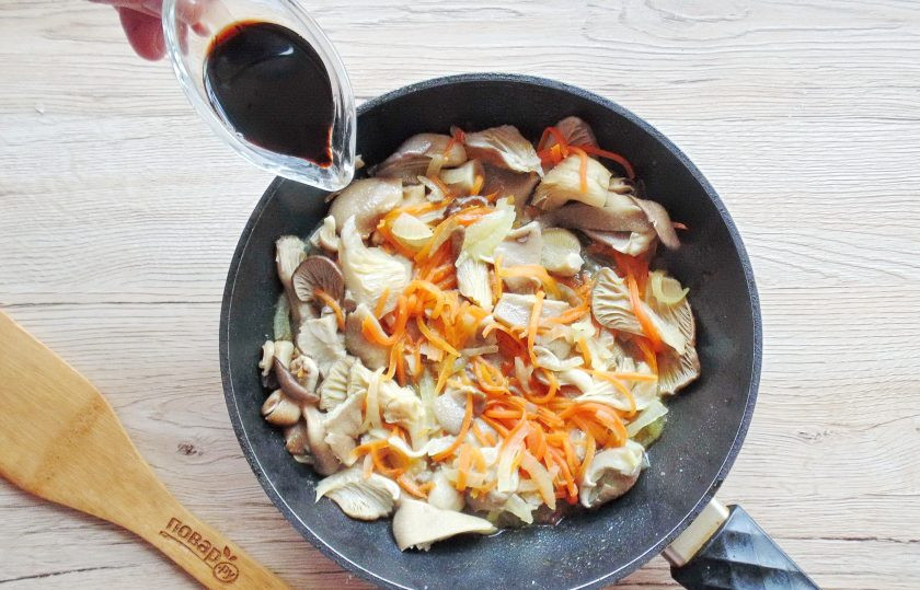 1. Этап. Фунчоза с древесными грибами: Влейте в сковороду соевый соус.