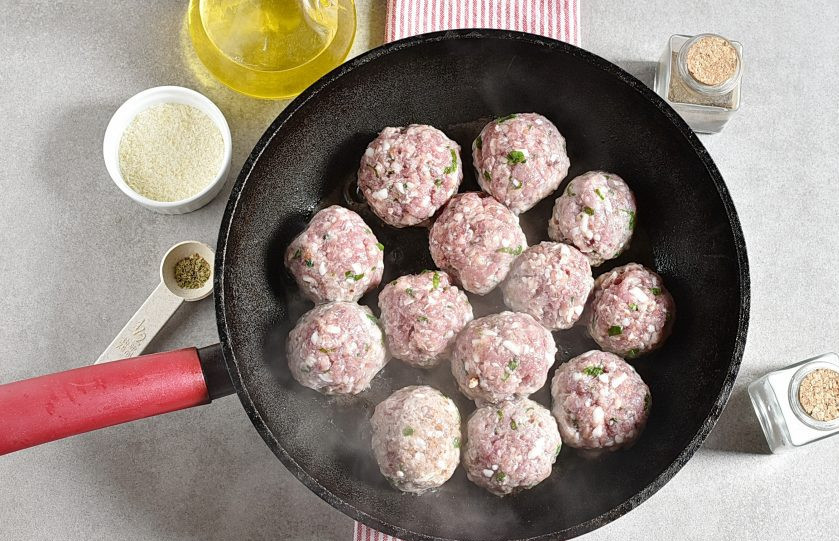 1. Этап. Итальянский ужин: Разогрейте оливковое масло в глубокой сковороде. Выложите фрикадельки и обжарьте до румянца одну сторону.