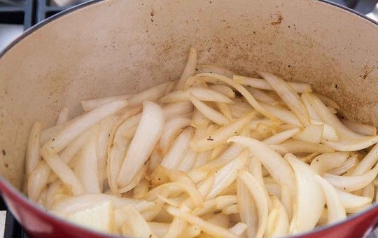 1. Этап. Говядина, тушеная в казане: 3. Переложите мясо в тарелку. Нарежьте полукольцами лук и обжарьте его в разогретом казане около 5-7 минут. Добавьте измельченный чеснок и нарезанную крупно морковь.