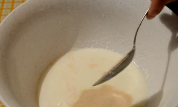 1. Этап. Жареные пирожки с капустой на кислом молоке: 1. В кислое молоко добавьте дрожжи и сахар, хорошо перемешайте, чтобы их растворить.