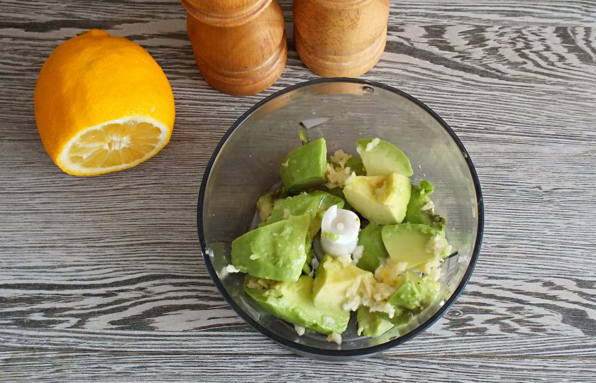 1. Этап. Мексиканские бургеры: Сделайте гуакамоле. В чашу блендера выложите разрезанный на несколько частей авокадо, 1 измельченный зубчик чеснока, растительное масло и сок из четвертинки лимона, соль, черный перец.